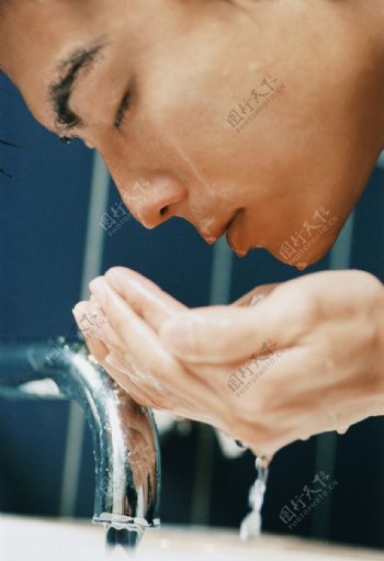 手捧水洗脸的男人图片