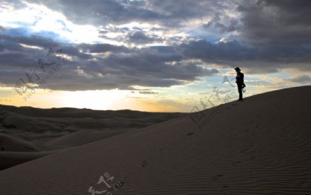 黄昏时在沙漠里的孤独的人图片