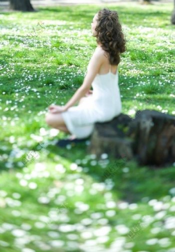 坐在绿草地上享受生活的美女图片
