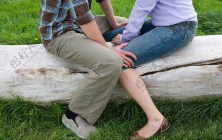 草地中聊天的亲密恋人腿部特写图片