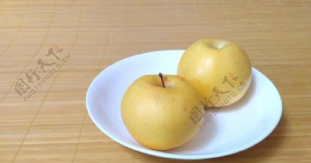 碟子上的两个黄苹果