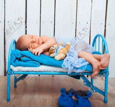 在蓝色小床上睡觉的婴儿图片