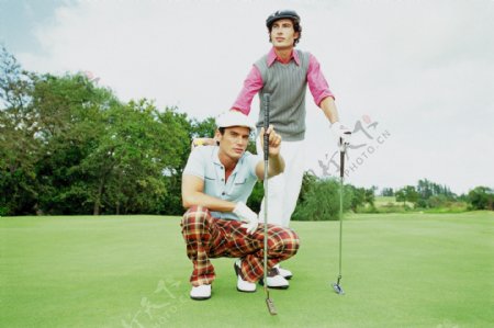 手拿高尔夫球杆的时尚男性图片