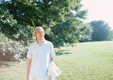 草地上散步的老人图片