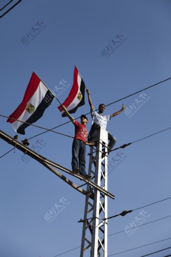 站在电线杆上举旗的男人图片