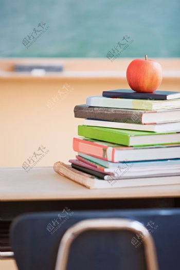 教室里课桌上书籍上的苹果图片