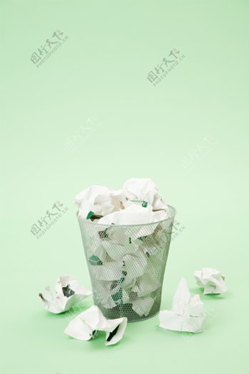 装满纸条的垃圾筐和散落的纸条图片图片