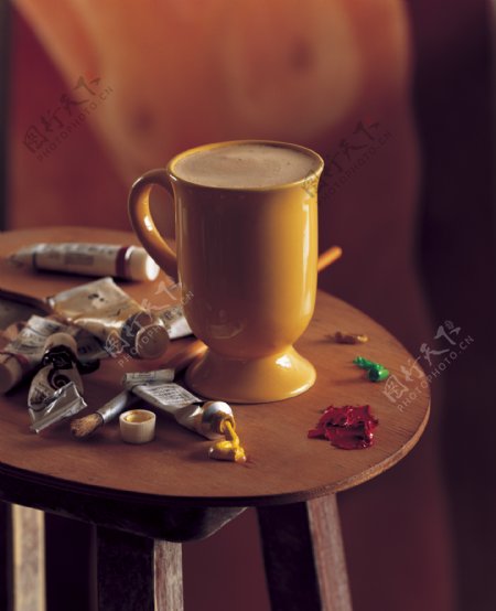 桌子上的颜料膏和一杯咖啡图片