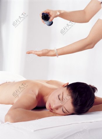 趴在美容床上正在做精油舒压的女人图片