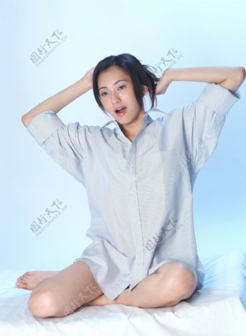 坐在床上伸懒腰的女人图片