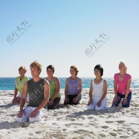 跪在沙滩上的男女图片