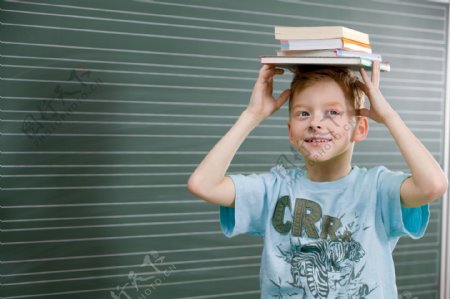 站着黑板前头顶着书本的小男孩图片