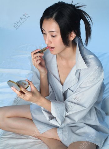 坐在床上抹口红性感女人图片