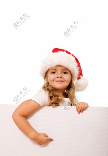 扶着空白广告牌带圣诞帽的可爱小女孩图片
