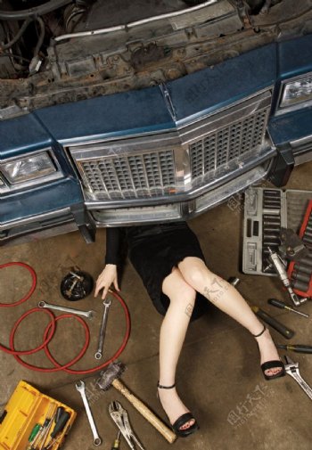 躺在地上修理汽车的女工人图片