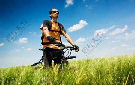 郊外田野上骑自行车的男人图片