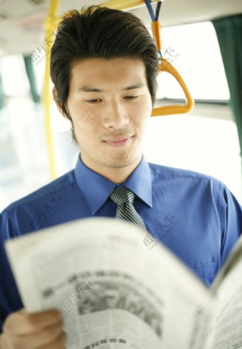 公交车上看报纸的商务人物图片
