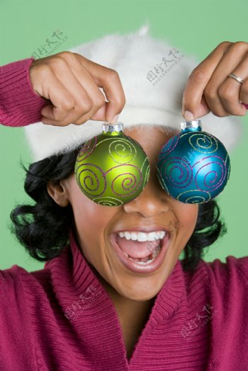 拿圣诞球当眼镜的快乐女人图片