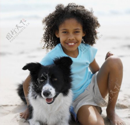 沙滩抱着小狗的小女孩图片
