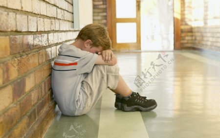 坐在学校走廊里面犯错误的小男孩图片