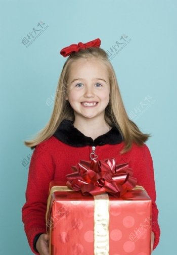 手捧礼盒的微笑小女孩图片