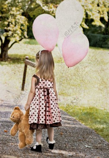 手拿玩具熊和气球的小女孩图片