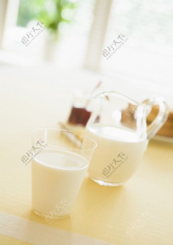 玻璃壶和杯子里的奶白色饮料