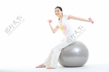 坐在健身球上做运动的少女图片图片