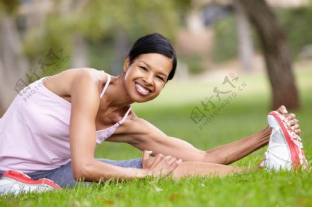 草地上压腿的女人图片
