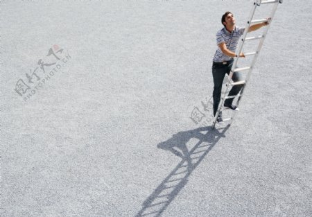爬梯子的商务男性图片