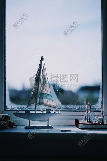 蓝白色帆船雕像靠近窗户