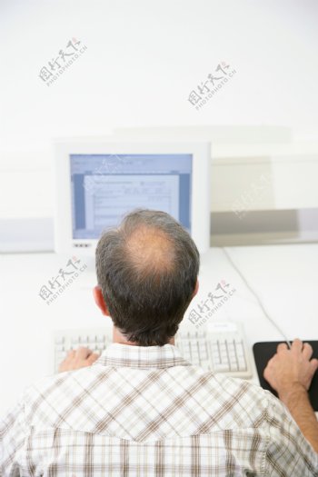 正在学习电脑的男人背影图片