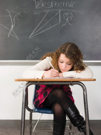 趴着课桌上写字的女孩图片