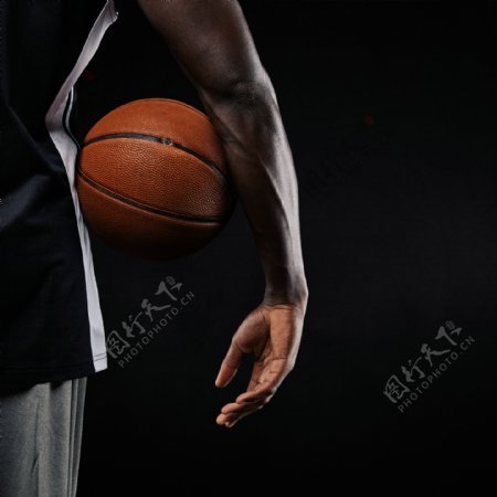 夹着篮球的运动员图片