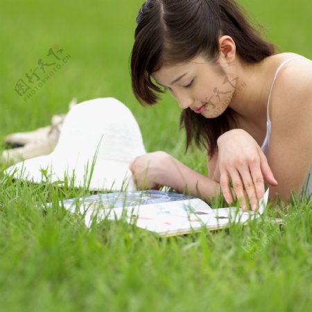 趴草地上看书的美女图片