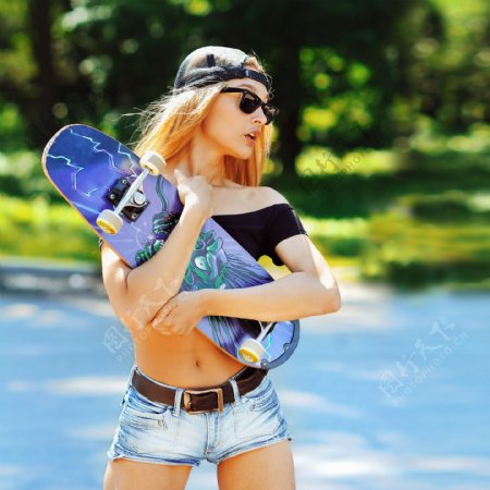 抱着滑板的运动时尚女孩图片