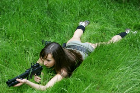 趴在草地上射击的女人图片