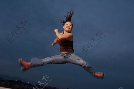 跳跃的时尚青年舞者图片
