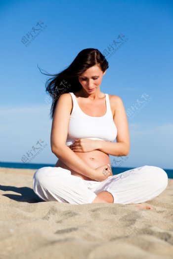 沙滩上坐着的孕妇图片