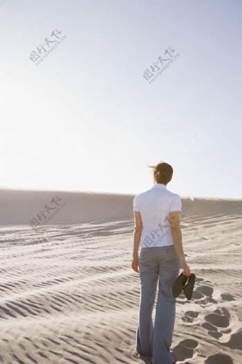 光脚走在沙漠中的女人背影图片