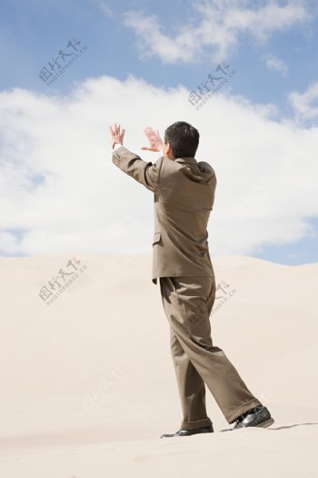沙漠中穿西装站着的男人图片图片