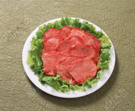 盘子里生菜叶上的肉片图片