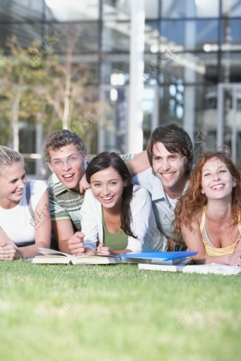 趴在草地上的开心大学生图片