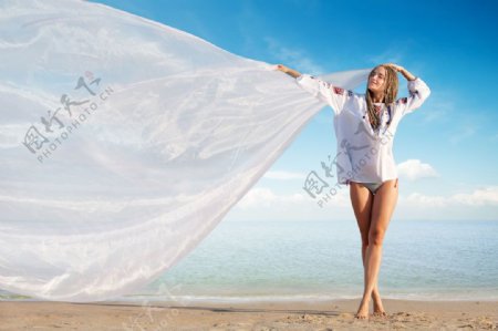沙滩上拿着丝巾的美女图片