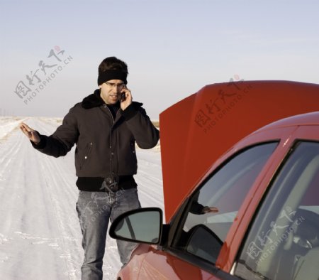 雪地上抛锚的轿车与男人图片