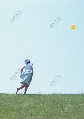 草地上追气球的美女图片