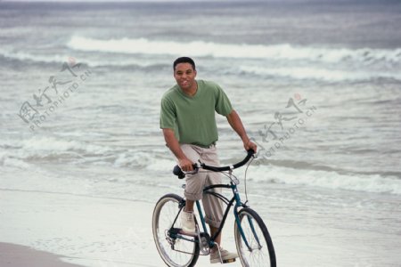 沙滩上骑车的黑人男性图片