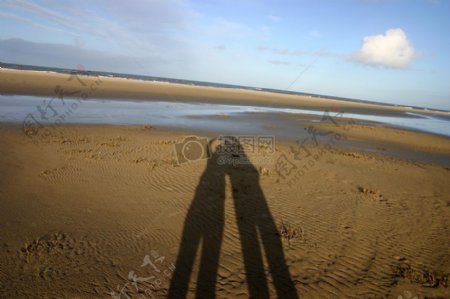 沙滩上一对情侣的阴影