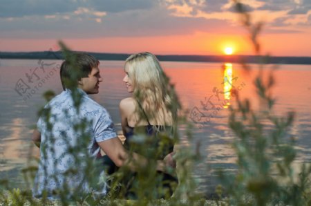 湖水边看日出的情侣图片
