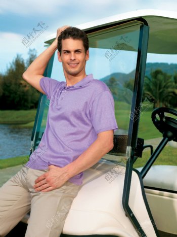 靠在高尔夫车上的男人图片